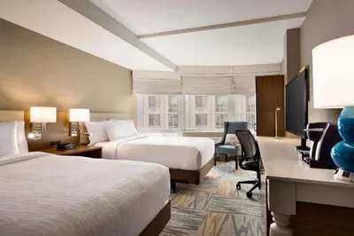 a hotel room with two beds and a desk at Hilton Garden Inn New York Times Square South in New York
