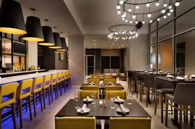 a restaurant with tables and chairs and a bar at Hilton Garden Inn New York Times Square South in New York