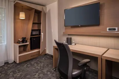 a hotel room with a desk and a television at Courtyard by Marriott Hershey Chocolate Avenue in Hershey