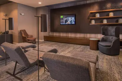 a waiting room with chairs and a flat screen tv at Courtyard by Marriott Hershey Chocolate Avenue in Hershey