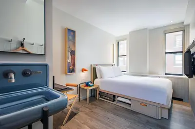 a bedroom with a bed and a bath tub at Moxy NYC Times Square in New York
