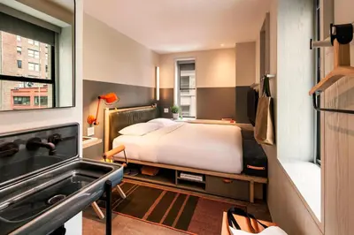 a bedroom with a bed and a bath tub at Moxy NYC Times Square in New York