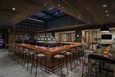 a bar with a bunch of stools in a room at Moxy NYC Times Square in New York