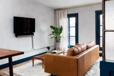 a living room with a couch and a tv at Lokal Hotel Old City in Philadelphia