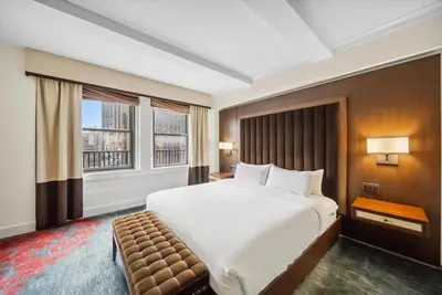 a bedroom with a large bed and a large window at Lexington Plaza Hotel in New York