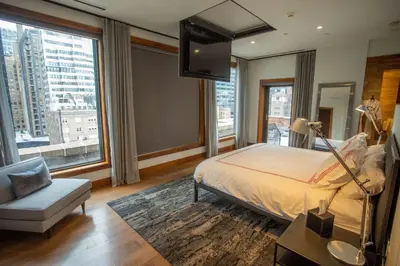 a bedroom with a bed and a tv and a chair at Lexington Plaza Hotel in New York