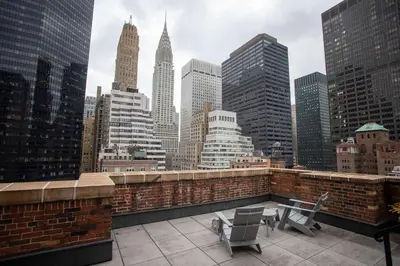 a balcony with two chairs and a view of a city at Lexington Plaza Hotel in New York