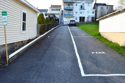 an empty parking lot next to a white building at Mountain View Suites in Jim Thorpe
