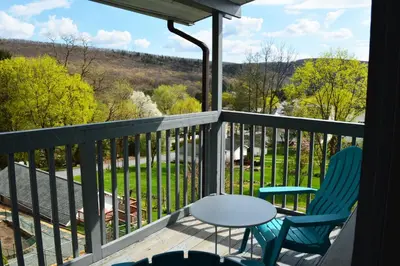 a balcony with two chairs and a table at Mountain View Suites in Jim Thorpe