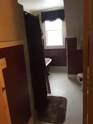 a bathroom with a sink and a toilet and a window at Victorian Charm Inn in Towanda