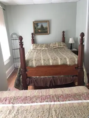 a bedroom with a bed and a picture on the wall at Victorian Charm Inn in Towanda