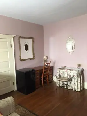 a living room with a table and a chair at Victorian Charm Inn in Towanda
