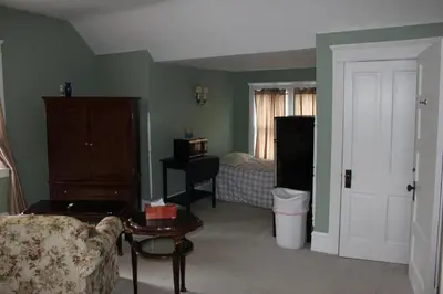 a living room with a couch and a bedroom at Victorian Charm Inn in Towanda