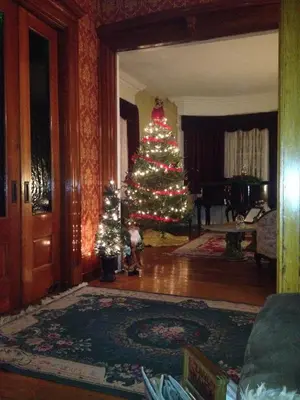 a christmas tree with lights in a living room at Victorian Charm Inn in Towanda