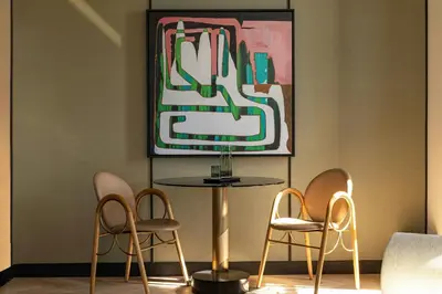a table and chairs in a room with a painting at W New York - Union Square in New York