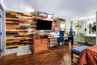 a bedroom with a wooden accent wall with a computer desk at Highland Inn New Cumberland in New Cumberland
