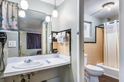 a bathroom with a sink and a toilet and a mirror at Highland Inn New Cumberland in New Cumberland