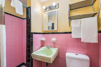 a pink bathroom with a sink and a toilet at Highland Inn New Cumberland in New Cumberland