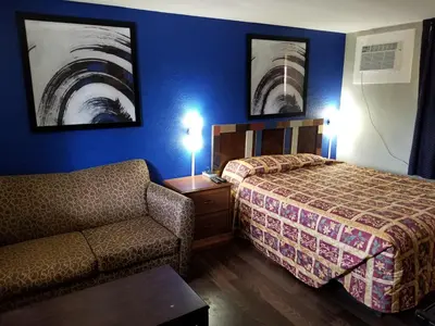 a hotel room with a bed and a couch at Highland Inn New Cumberland in New Cumberland