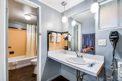 a bathroom with a sink and a mirror at Highland Inn New Cumberland in New Cumberland