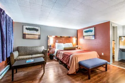 a hotel room with a bed and a chair at Highland Inn New Cumberland in New Cumberland