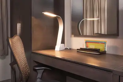 a desk with a chair and a mirror and a lamp at Hilton Garden Inn NYC Financial Center/Manhattan Downtown in New York