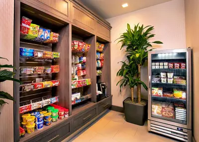 a grocery store aisle with food and a plant at Hilton Garden Inn NYC Financial Center/Manhattan Downtown in New York
