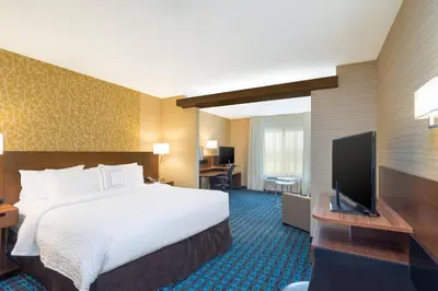 a hotel room with a bed and a flat screen tv at Fairfield Inn & Suites by Marriott Bloomsburg in Bloomsburg