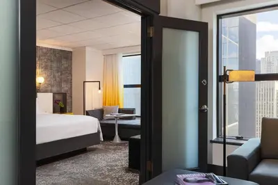a hotel room with a bed and a living room at Renaissance New York Times Square by Marriott in New York