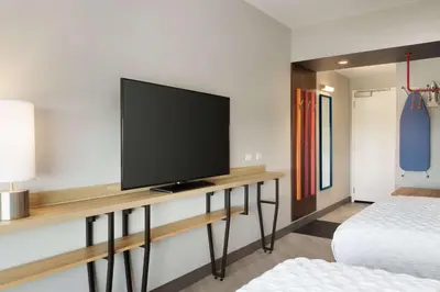 a room with a flat screen tv on a wall at Tru By Hilton Lancaster East in Lancaster