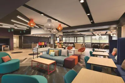 a rendering of a lobby with tables and chairs at Tru By Hilton Lancaster East in Lancaster