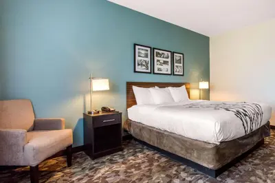 a hotel room with a bed and a chair at Sleep Inn & Suites Middletown - Goshen in Middletown