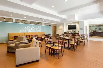 a restaurant with tables and chairs and a bar at Sleep Inn & Suites Middletown - Goshen in Middletown