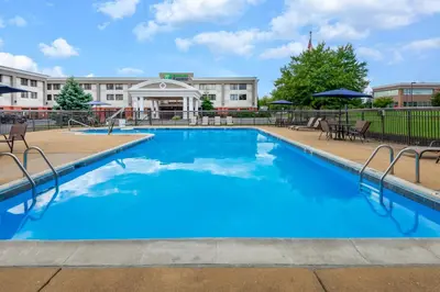 a pool at a hotel with chairs and umbrellas at Holiday Inn Express Philadelphia NE-Bensalem by IHG in Bensalem