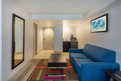 a living room with a blue couch and a table at Holiday Inn Express Philadelphia NE-Bensalem by IHG in Bensalem