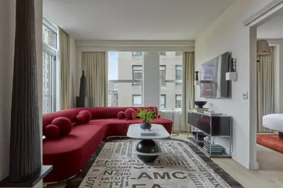 a living room with a red couch and a table at Hotel Park Ave NYC in New York