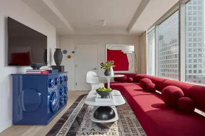 a living room with a red couch and a blue cabinet at Hotel Park Ave NYC in New York