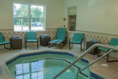 a hot tub in a waiting room with chairs and a pool at Residence Inn by Marriott Harrisburg Carlisle in Carlisle