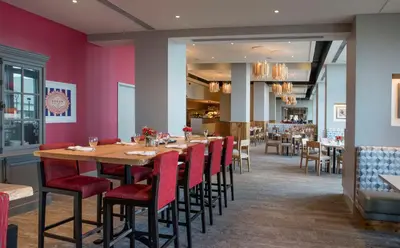 a dining room with a long table and red chairs at Hilton Philadelphia at Penn's Landing in Philadelphia