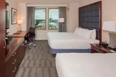a hotel room with two beds and a desk at Hilton Philadelphia at Penn's Landing in Philadelphia
