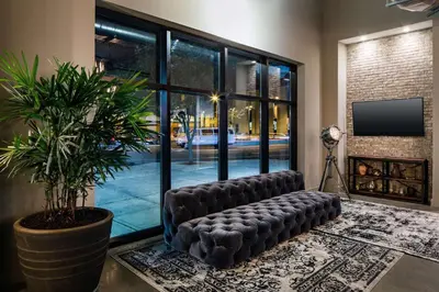 a room with a leather bench in a room with a plant at Watt Hotel Tapestry Collection by Hilton in Rahway