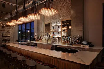 a bar with a counter and chairs in a room at Watt Hotel Tapestry Collection by Hilton in Rahway