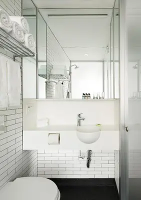 a bathroom with a sink and a toilet and a mirror at Pod Times Square in New York