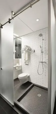 a white bathroom with a toilet and a shower at Pod Times Square in New York