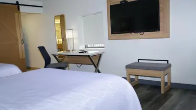 a hotel room with a bed and a desk and a tv at Waterfront Inn PHL Airport in Essington