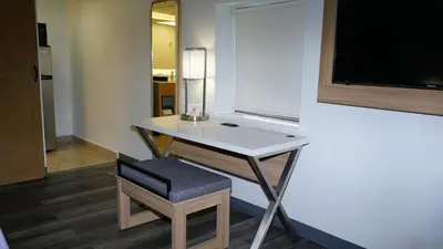 a room with a desk and a chair and a television at Waterfront Inn PHL Airport in Essington