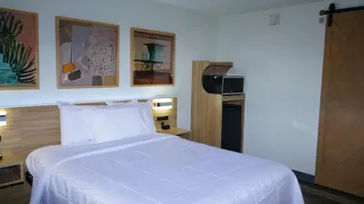 a bedroom with a large bed with white sheets at Waterfront Inn PHL Airport in Essington