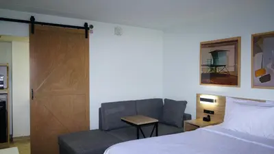 a bedroom with a bed and a chair and a door at Waterfront Inn PHL Airport in Essington