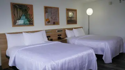 two beds in a hotel room with white sheets at Waterfront Inn PHL Airport in Essington