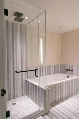 a bathroom with a tub and a glass shower at The Dominick Hotel in New York